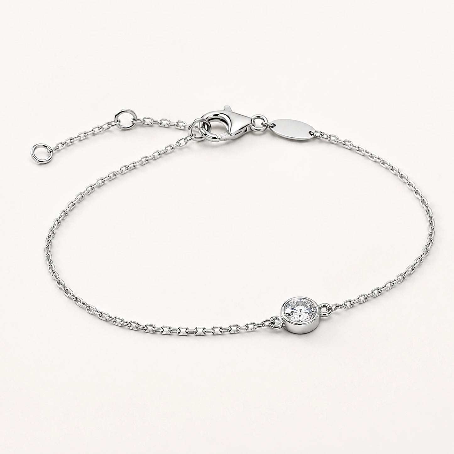 Oblique side view of a bezel-set white crystal silver bracelet