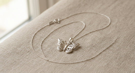 Delicate sterling silver butterfly pendant necklace on a neutral background