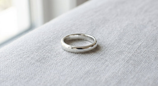 A polished sterling silver ring resting on a neutral surface.