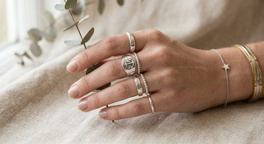 Curated sterling silver rings stacked on fingers with balanced proportions
