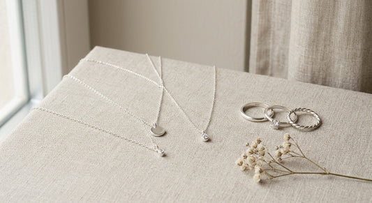 Elegant sterling silver jewelry organized neatly on a clean neutral surface.