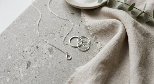 Elegant sterling silver pendant necklace arranged on a neutral surface