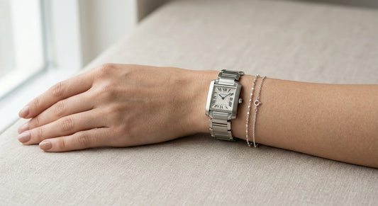 Elegant silver watch paired with a sterling silver bracelet on a neutral background