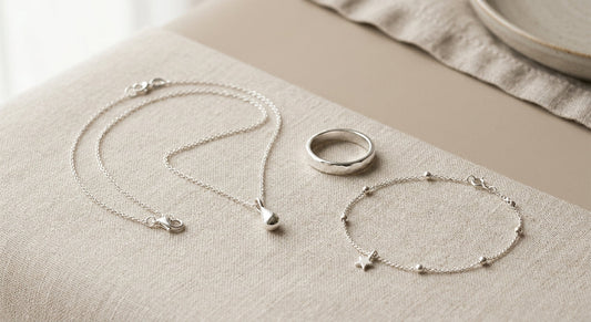 Assorted sterling silver jewelry pieces displayed on a neutral surface.