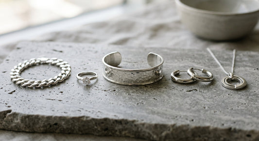 Sterling silver and white gold jewelry displayed on a neutral surface