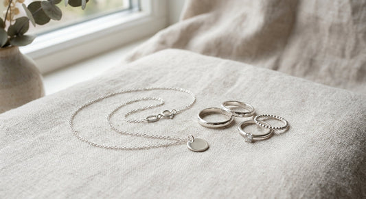 Elegant sterling silver jewelry resting on a neutral linen surface
