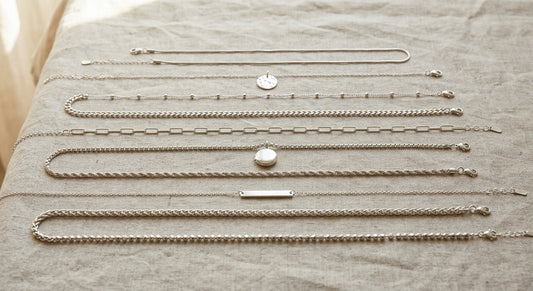 Elegant sterling silver necklaces in various standard lengths laid out on a neutral surface