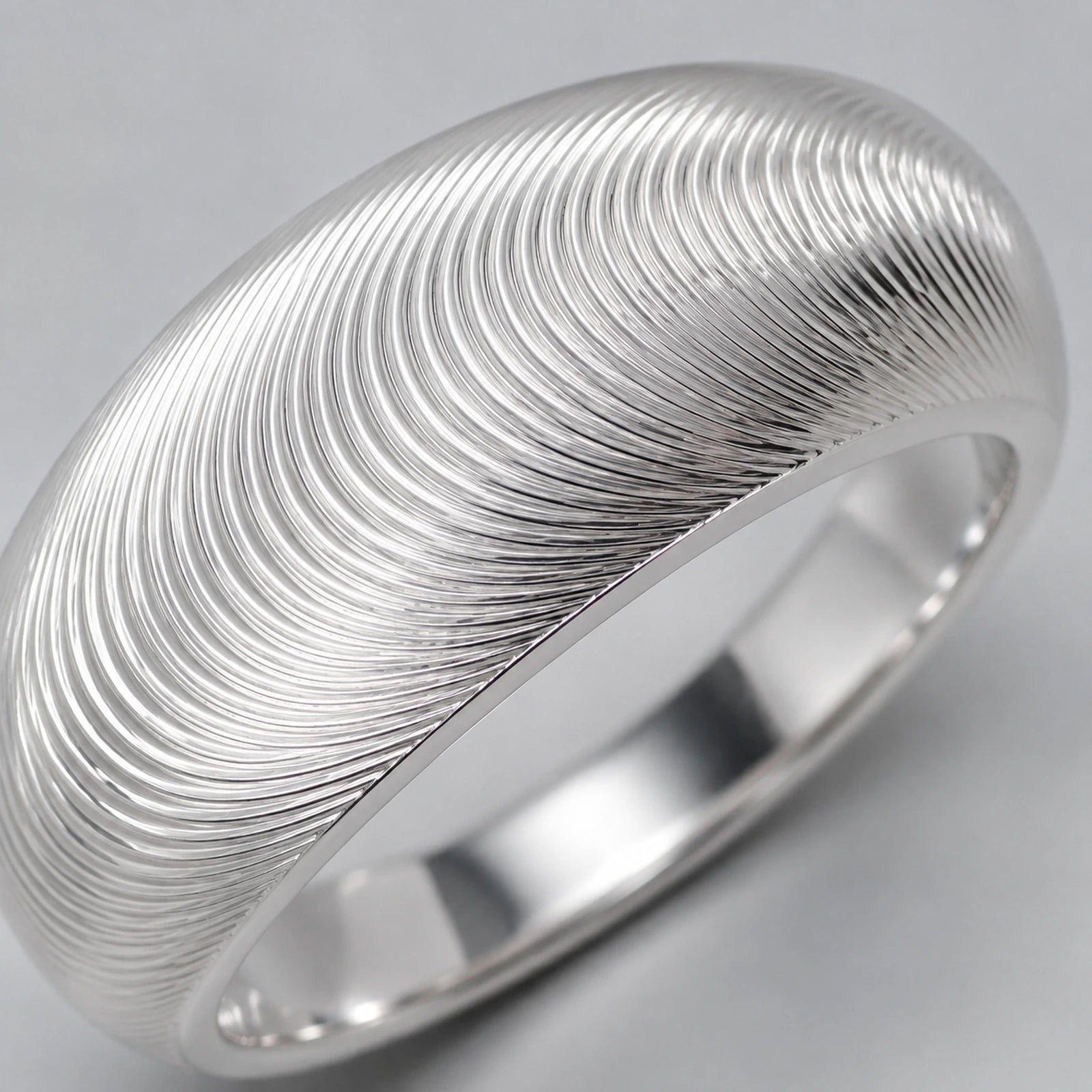Close-up of fine concentric fingerprint texture on silver ring