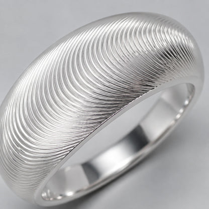 Close-up of fine concentric fingerprint texture on silver ring