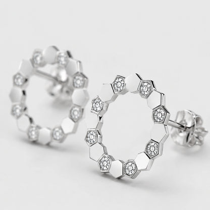 Macro close-up of clear stone settings and polished facets on open circle stud earrings