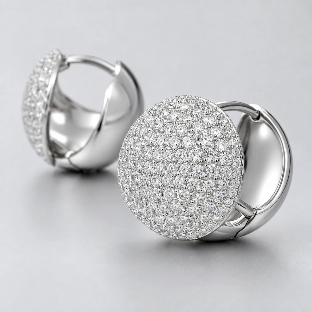 Macro close-up of clear stone accents on convex round dome huggie earrings