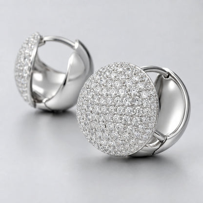 Macro close-up of clear stone accents on convex round dome huggie earrings