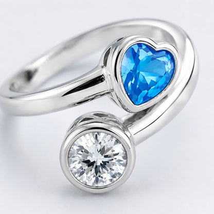 Close-up of blue heart and clear round accents in polished silver settings