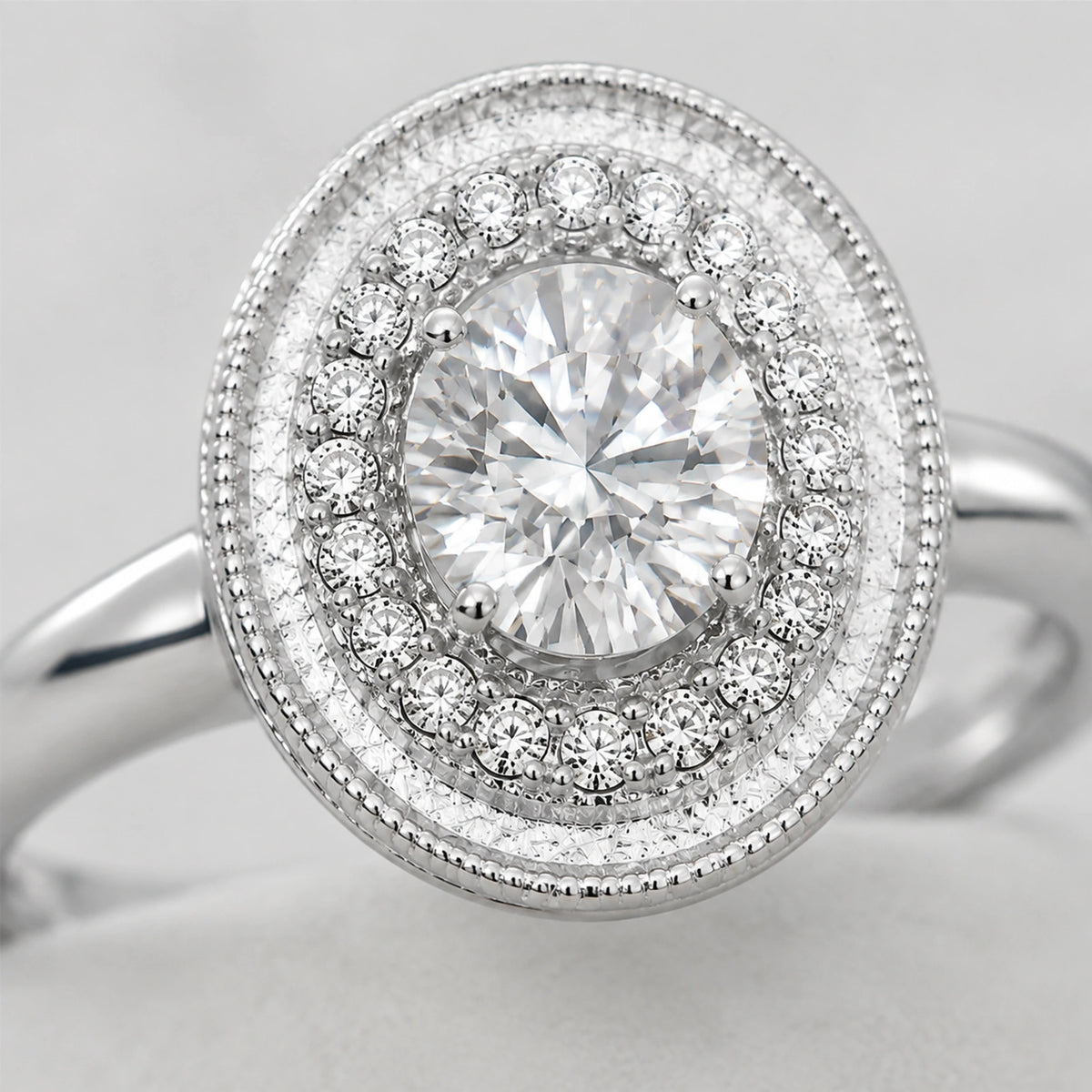Close-up of the clear faceted center stone, halo and beaded oval border
