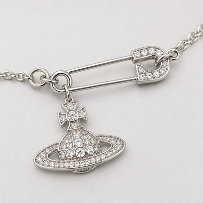 Close-up of the stone-accented safety pin centerpiece and dangling orbital charm.