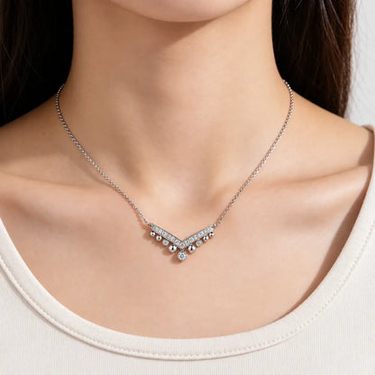 Close-up of a woman wearing a delicate silver crystal chevron necklace.