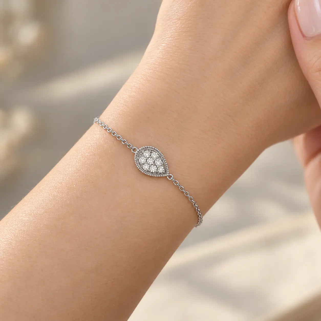 Delicate silver crystal teardrop bracelet shown in a close-up wrist styling view.