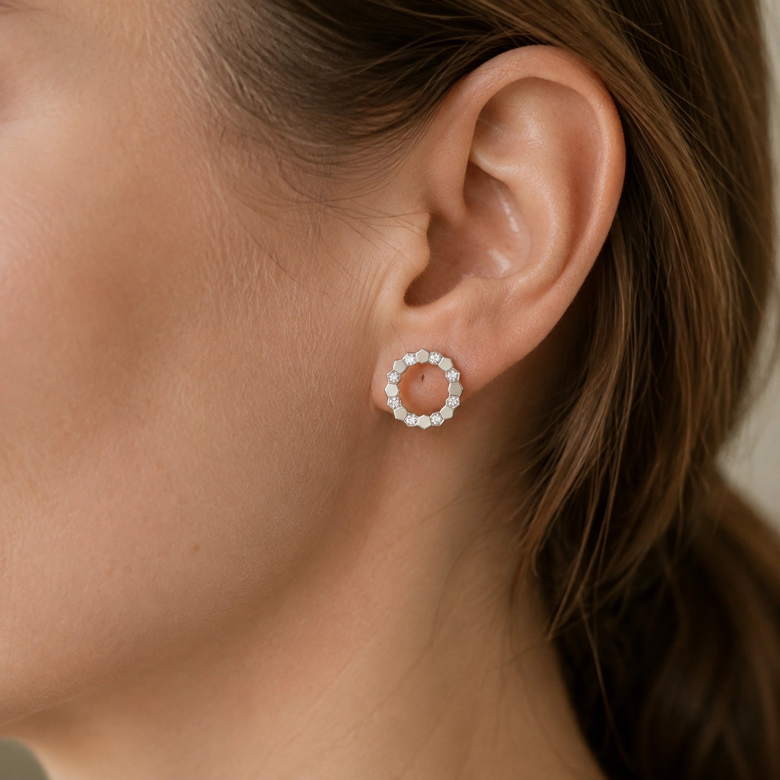 Close wearing view of a geometric open circle stud earring on an adult Western model
