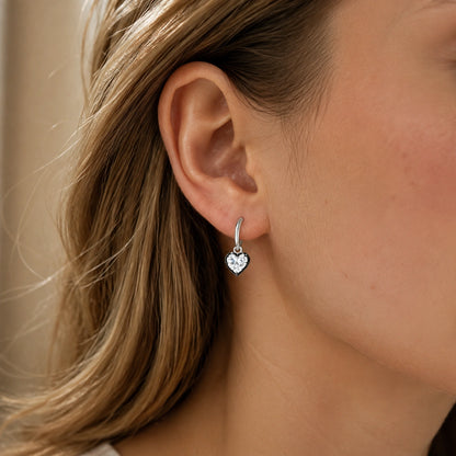 Heart crystal huggie earring worn close up by a Western woman