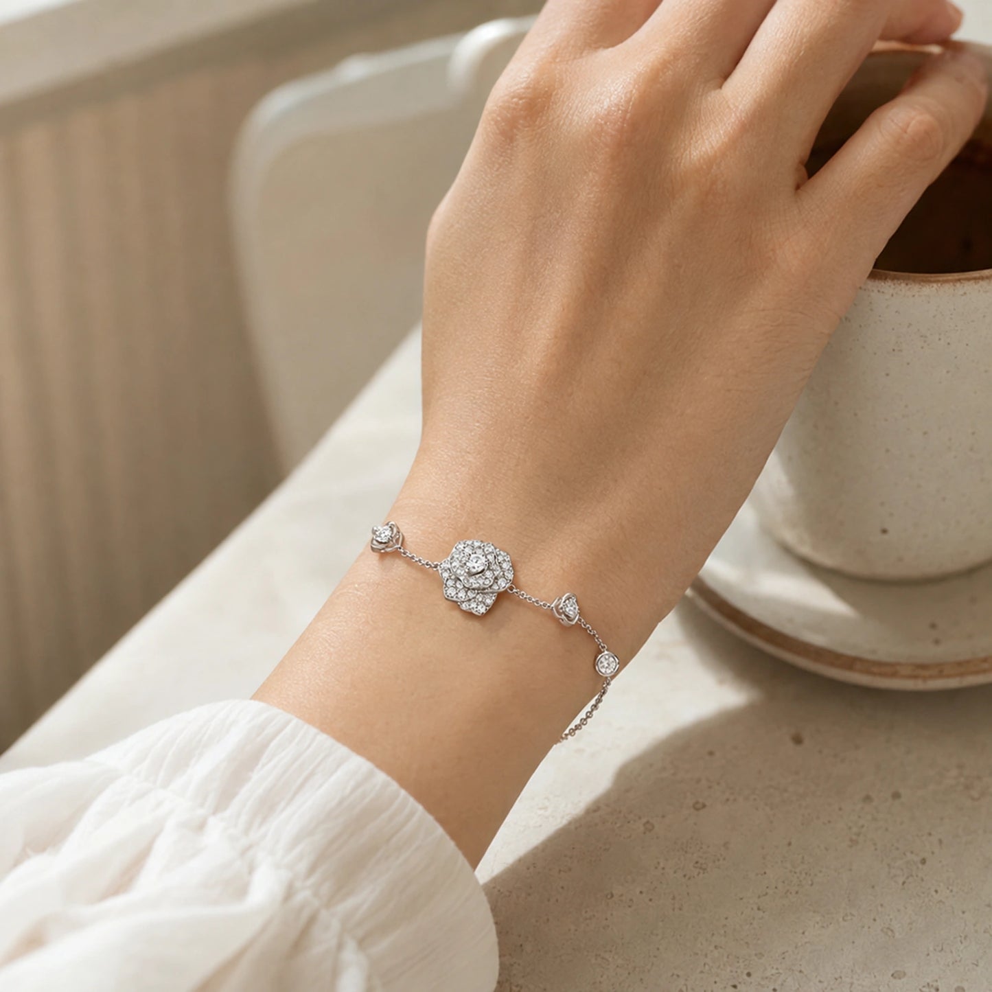 Lifestyle view of crystal rose bracelet worn beside a neutral ceramic cup