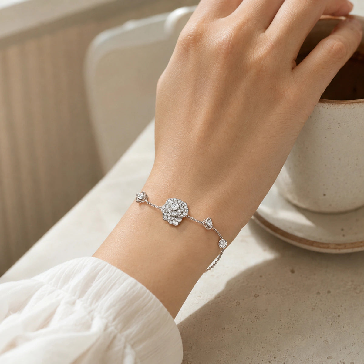 Lifestyle view of crystal rose bracelet worn beside a neutral ceramic cup