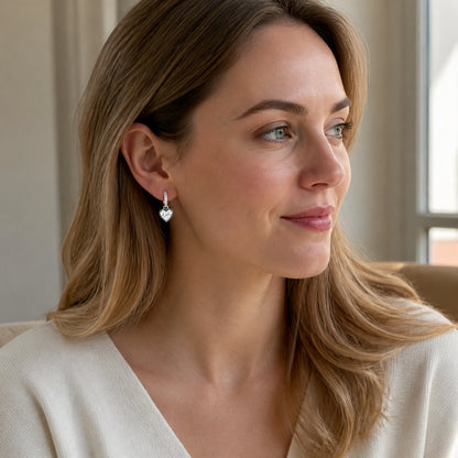 Western woman wearing silver heart crystal huggie earrings