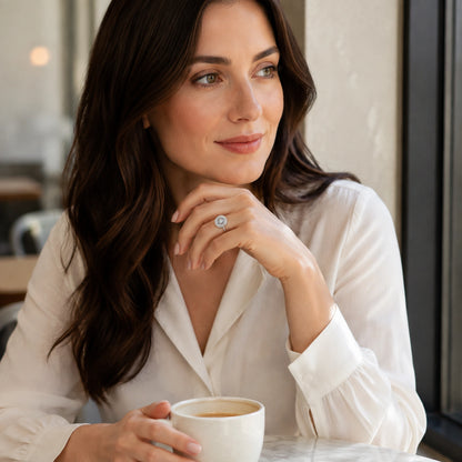 Woman wearing an oval halo adjustable sterling silver ring in a café