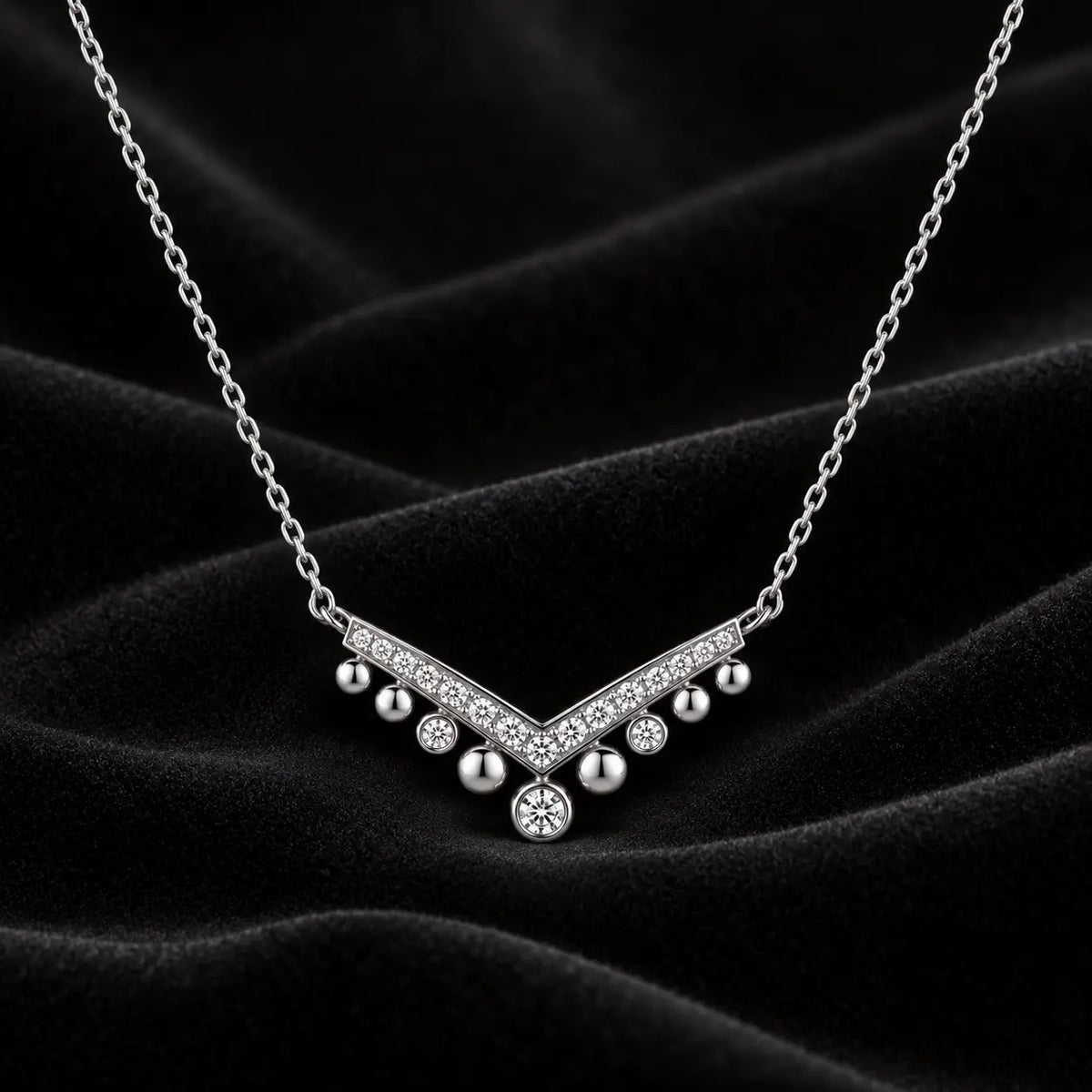 Silver crystal chevron drop necklace displayed on black velvet.