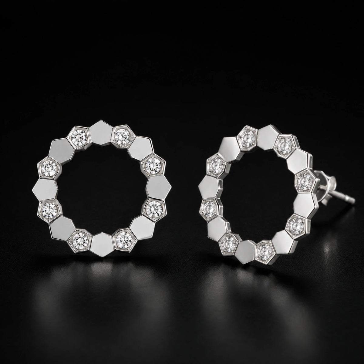 Geometric open circle stud earrings photographed on a premium dark background