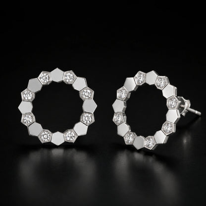 Geometric open circle stud earrings photographed on a premium dark background