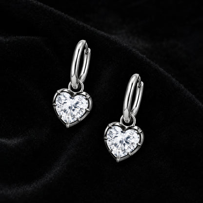 Pair of silver heart crystal huggie earrings on black velvet
