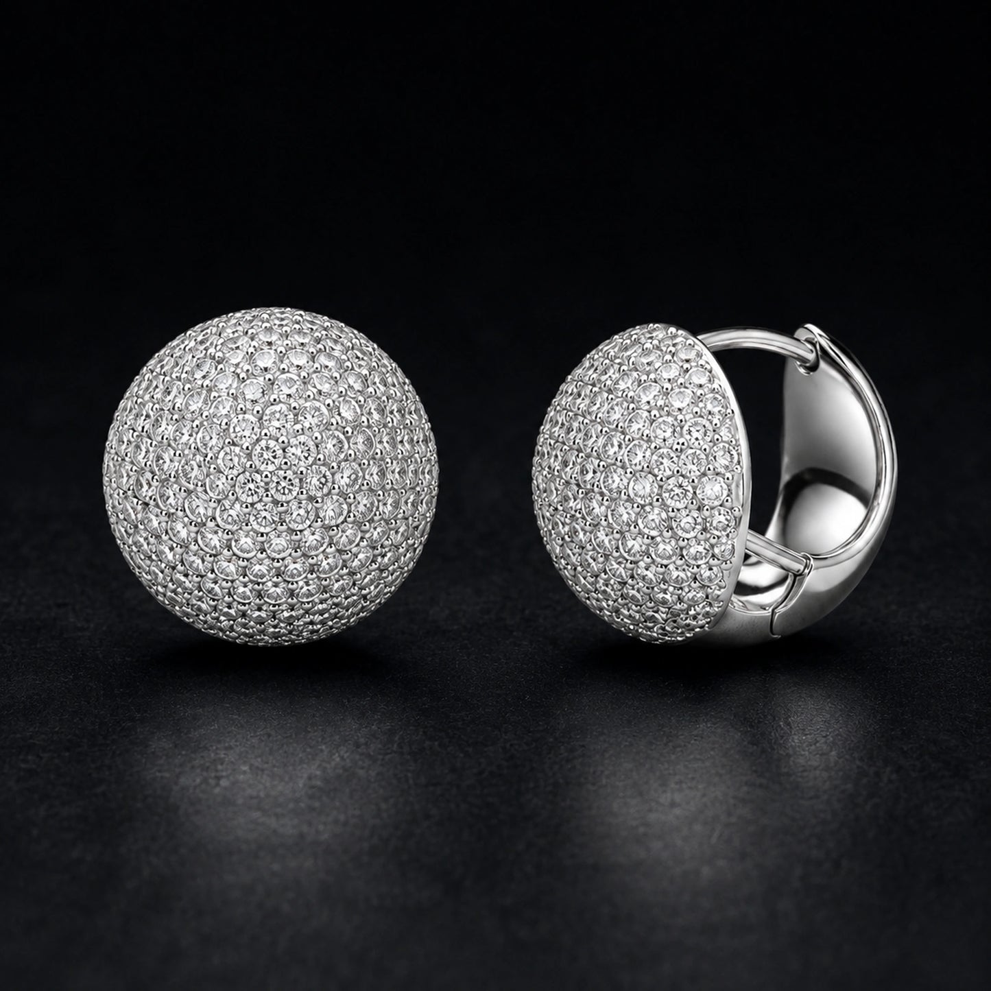 Round pave dome huggie earrings photographed on a premium dark background