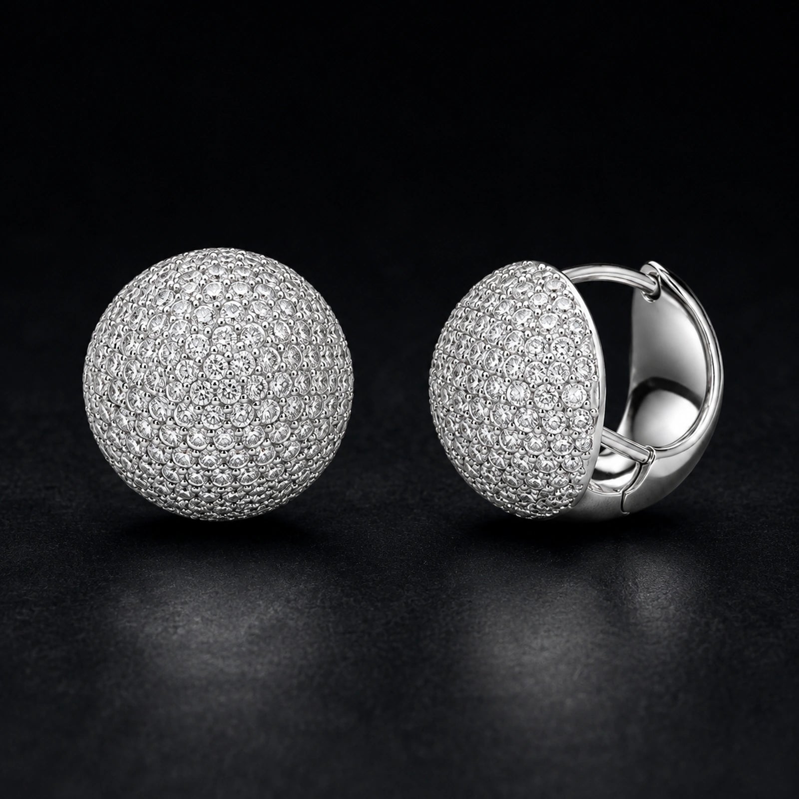 Round pave dome huggie earrings photographed on a premium dark background