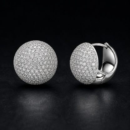 Round pave dome huggie earrings photographed on a premium dark background