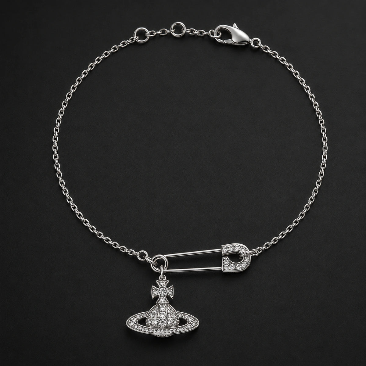 Silver-tone safety pin orb charm bracelet displayed on a dark studio background.