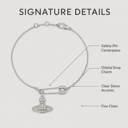 Feature guide highlighting the safety-pin centerpiece, orbital charm, clear stones and fine chain.