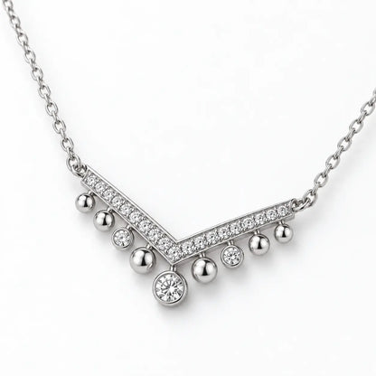 Shallow angled view showing the profile of a silver crystal chevron necklace.
