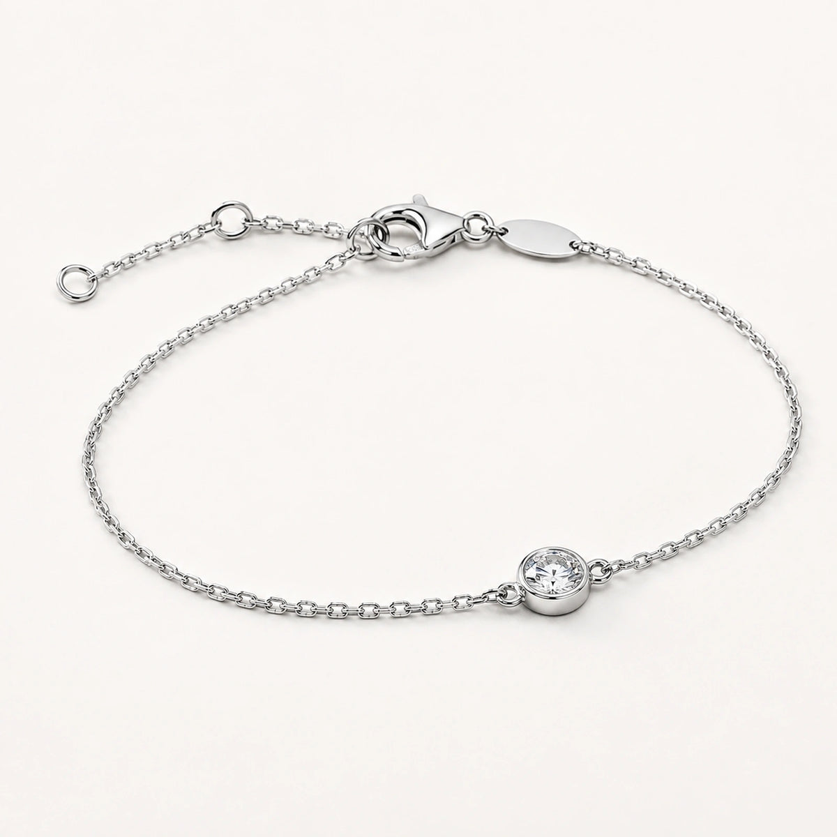 Oblique side view of a bezel-set white crystal silver bracelet