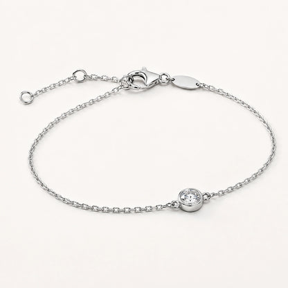 Oblique side view of a bezel-set white crystal silver bracelet