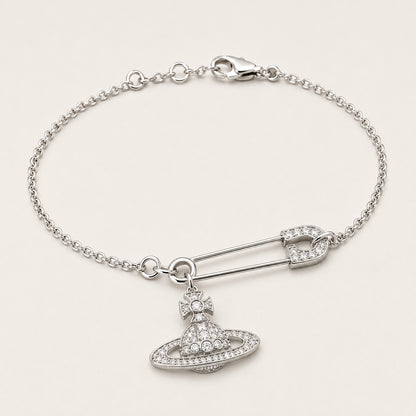 Three-quarter side view of a silver-tone safety pin centerpiece and orbital charm bracelet.