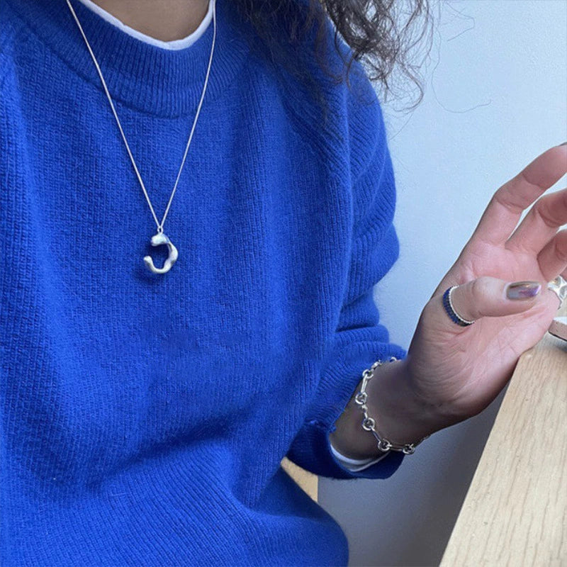 Geometric C-shaped S925 silver necklace detail with an irregular half-circle design
